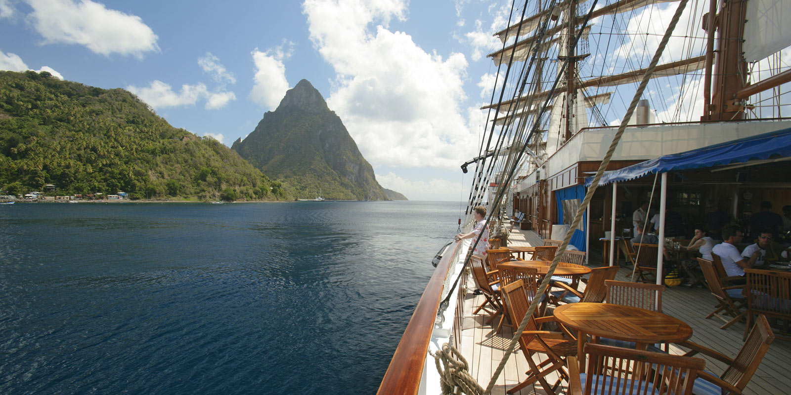 Segelfartyget Sea Cloud II med utsikt över vacker natur på fastlandet.