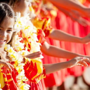 Glada barn som dansar med Hawaiikransar runt halsen.