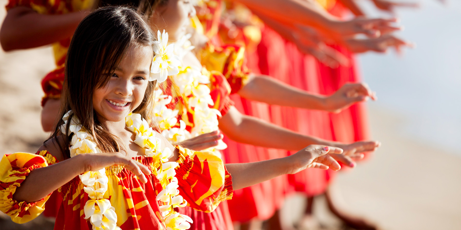 Glada barn som dansar med Hawaiikransar runt halsen.