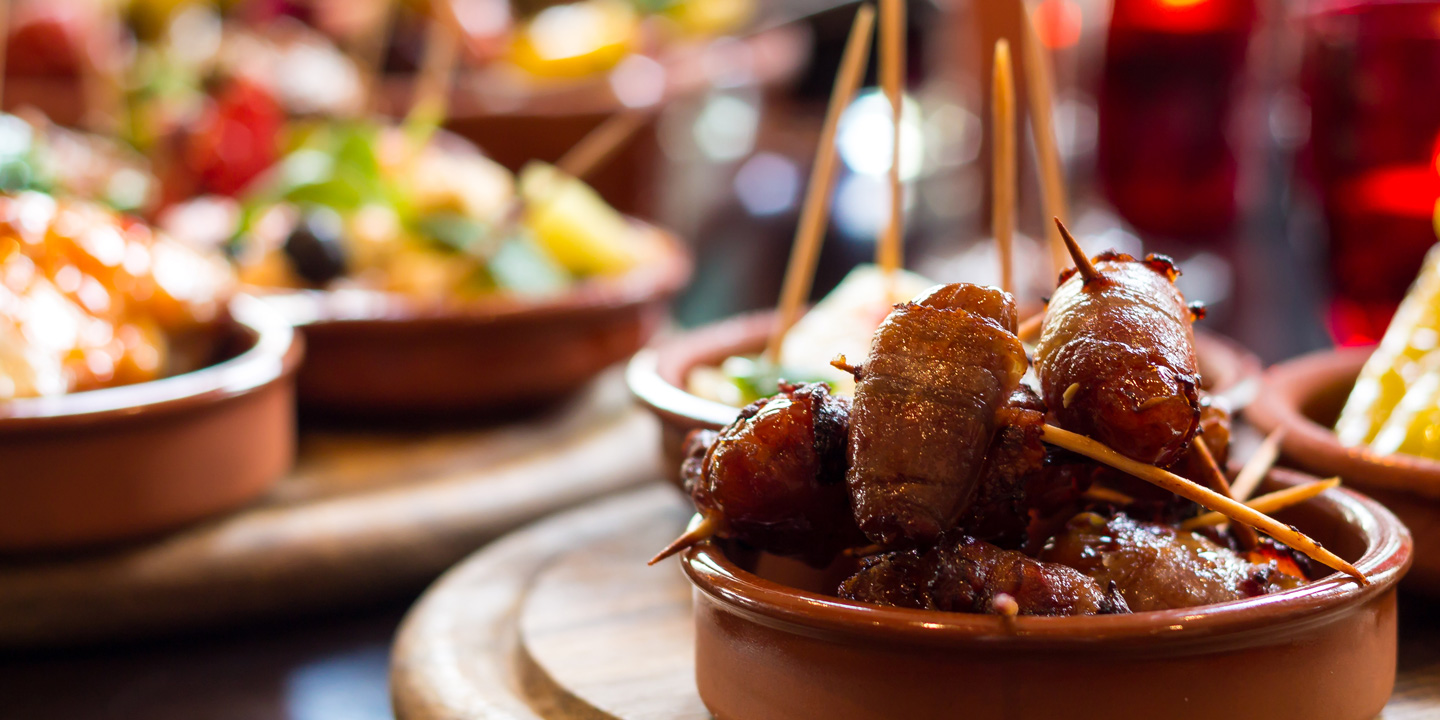 Flera vackra spanska lertallrikar med färgrika tapasrätter.