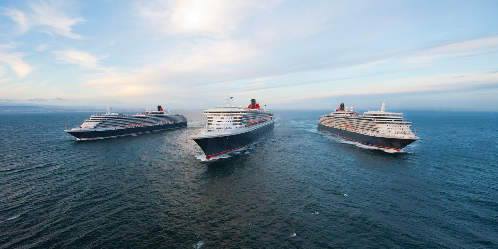 Tre av Cunards fartyg, bredvid varandra ute till havs.
