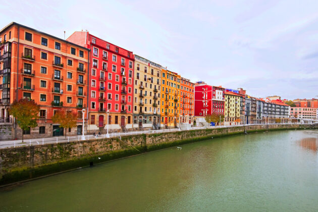 Färgglada byggnader längs floden Nervion som rinner genom Bilbao, Spanien.