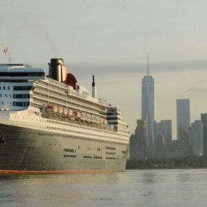 Cunards kryssningsfartyg Queen Mary 2 med New York, USA, skyline i bakgrunden.