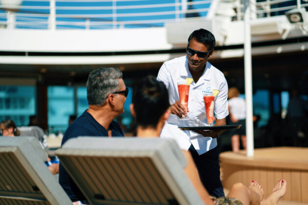 Gäster blir serverade drinkar på pooldäck, ombord på Azamaras fartyg.
