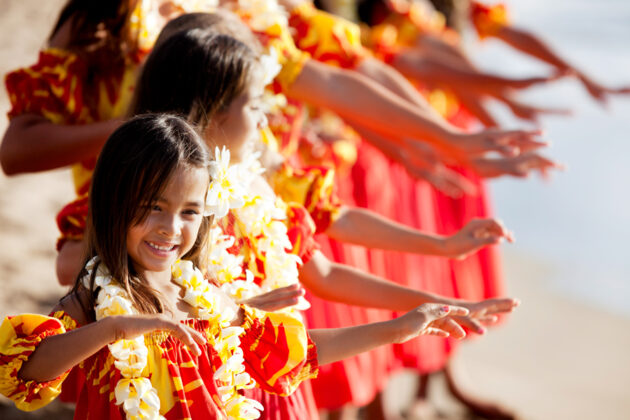 Glada barn som dansar med Hawaiikransar runt halsen.